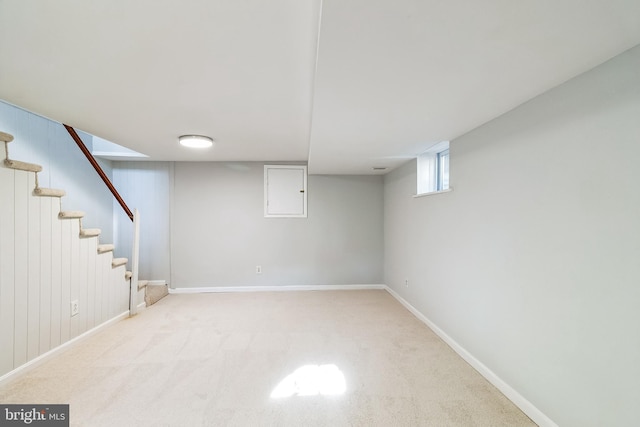 basement featuring carpet flooring, stairway, and baseboards