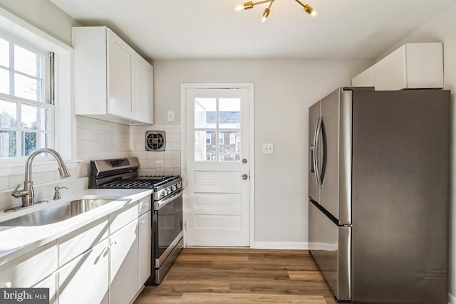 kitchen featuring appliances with stainless steel finishes, a sink, a wealth of natural light, and decorative backsplash