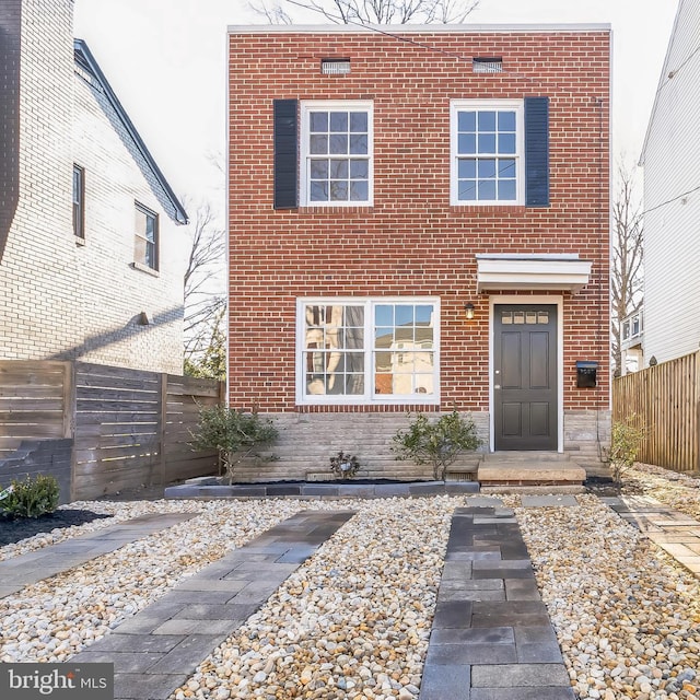 view of front facade with fence and brick siding