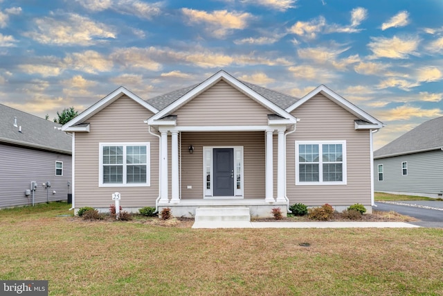 view of front of house with covered porch and a front yard