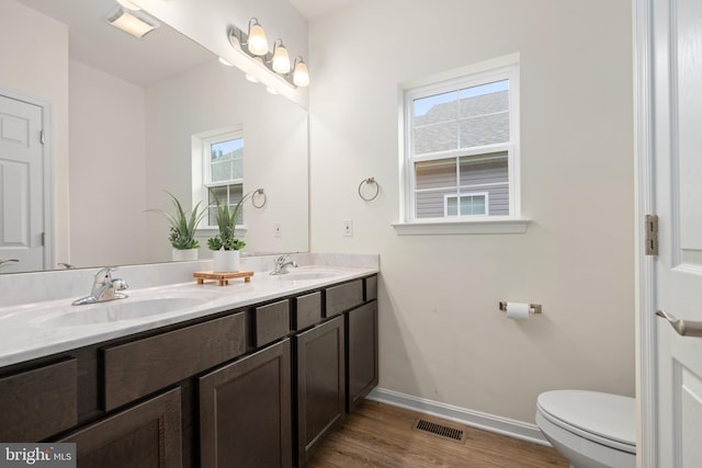 bathroom with hardwood / wood-style floors, vanity, toilet, and plenty of natural light