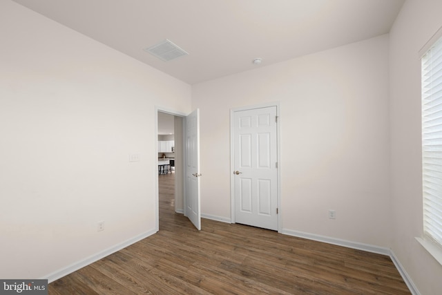 unfurnished bedroom with dark wood-type flooring