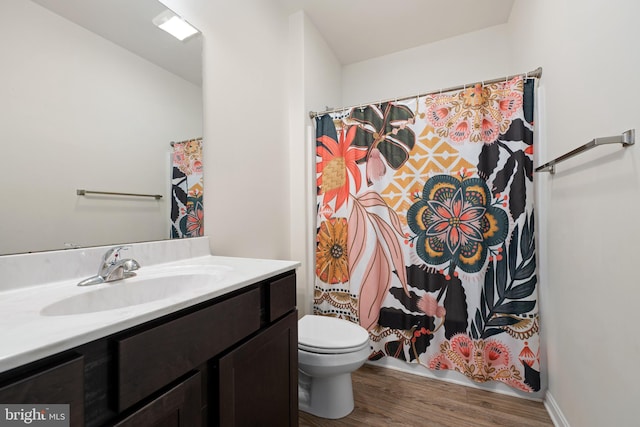 bathroom featuring hardwood / wood-style floors, vanity, a shower with shower curtain, and toilet