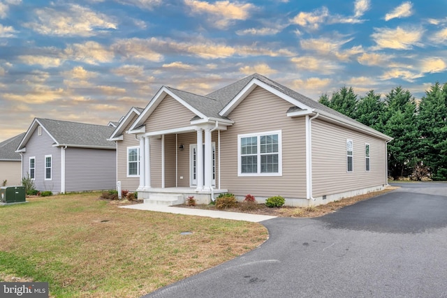 view of front of home featuring central AC unit and a lawn