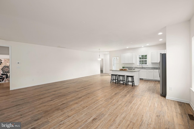 living room with light hardwood / wood-style floors and sink