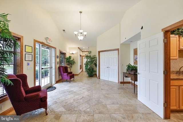 interior space featuring high vaulted ceiling and a notable chandelier