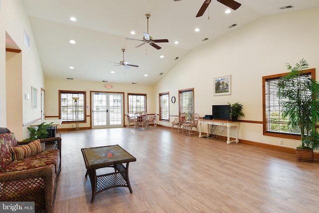 living room featuring ceiling fan, french doors, high vaulted ceiling, and light hardwood / wood-style flooring