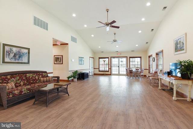 living room with ceiling fan, light hardwood / wood-style flooring, and high vaulted ceiling