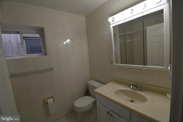 bathroom featuring vanity, tile walls, and toilet