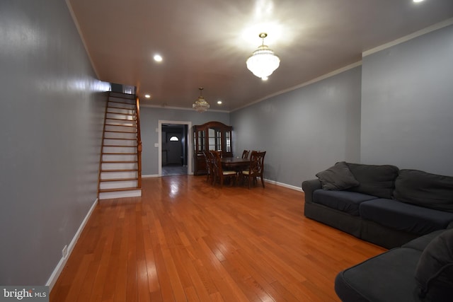 unfurnished living room with an inviting chandelier, wood-type flooring, and ornamental molding