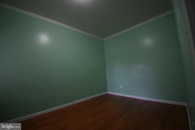 spare room featuring crown molding and wood-type flooring