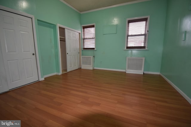 unfurnished bedroom featuring hardwood / wood-style floors and ornamental molding