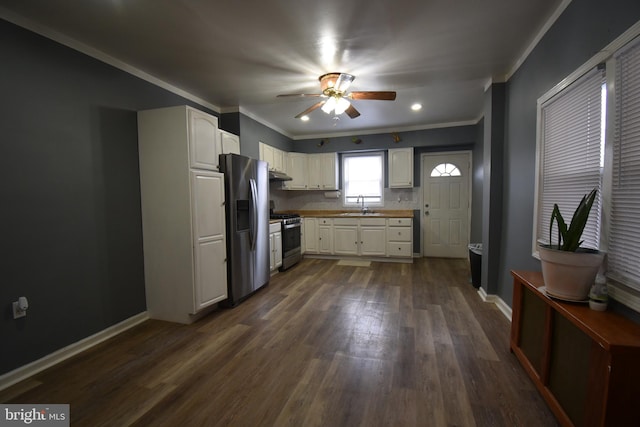 kitchen with appliances with stainless steel finishes, dark hardwood / wood-style floors, white cabinetry, and sink