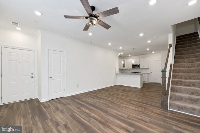 unfurnished living room with ornamental molding, ceiling fan, dark wood-type flooring, and sink