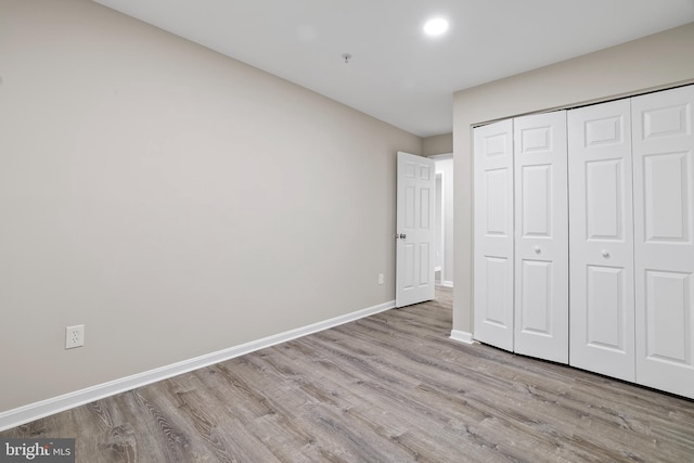 unfurnished bedroom featuring a closet and light hardwood / wood-style floors