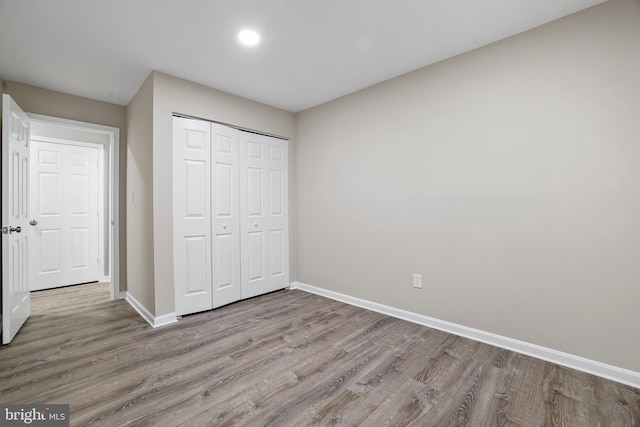 unfurnished bedroom with light hardwood / wood-style flooring and a closet