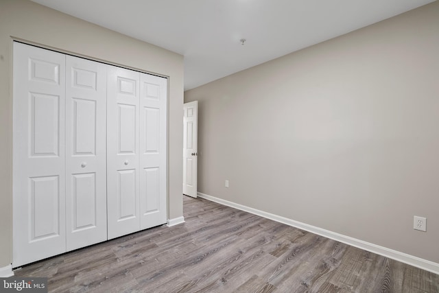 unfurnished bedroom featuring light hardwood / wood-style flooring and a closet