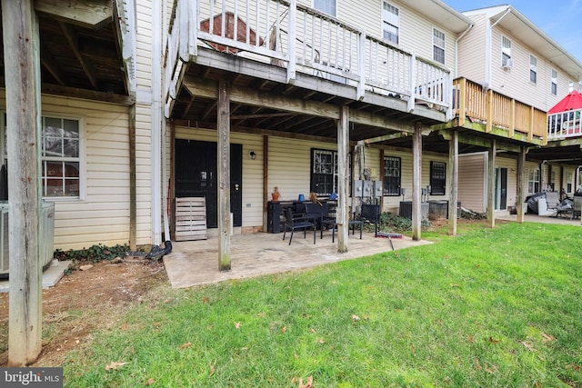 rear view of house featuring a lawn, a deck, a patio, and central AC