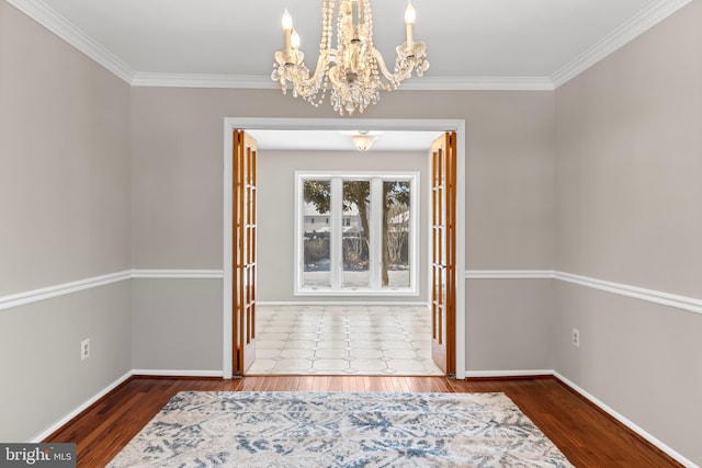 interior space with french doors, a chandelier, ornamental molding, and hardwood / wood-style floors