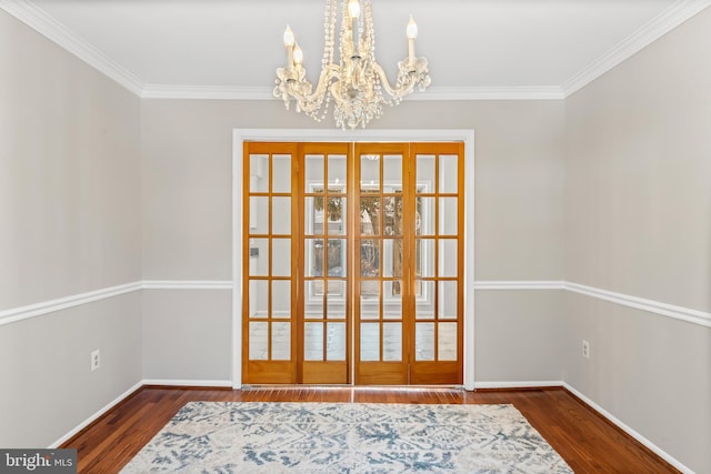 dining area featuring dark wood-type flooring, crown molding, french doors, and an inviting chandelier