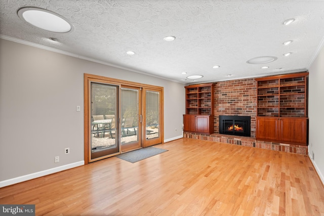 unfurnished living room with a textured ceiling, built in features, crown molding, and a fireplace