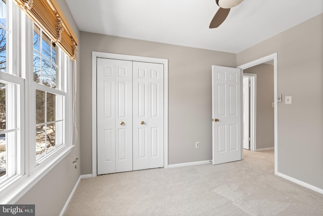 unfurnished bedroom with ceiling fan, light colored carpet, and a closet