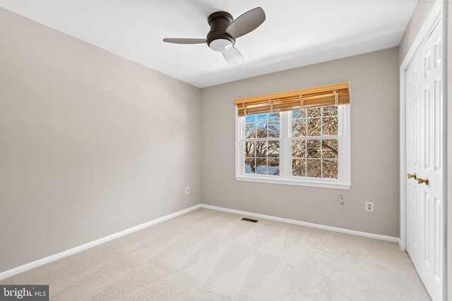 unfurnished bedroom with ceiling fan, light colored carpet, and a closet