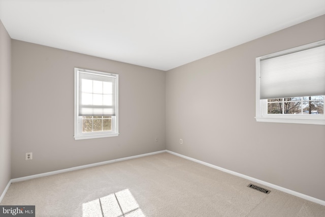 carpeted spare room featuring a healthy amount of sunlight