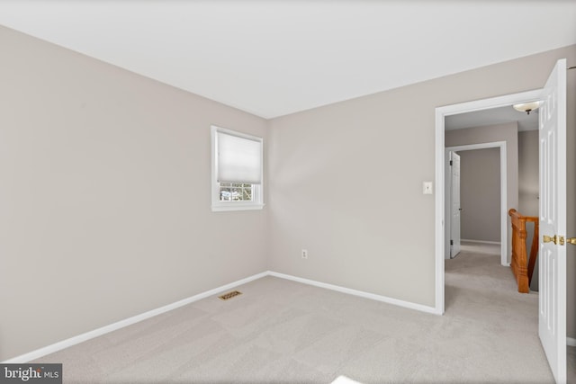 unfurnished room featuring light colored carpet