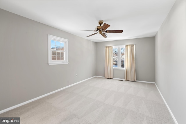 spare room with ceiling fan and light colored carpet