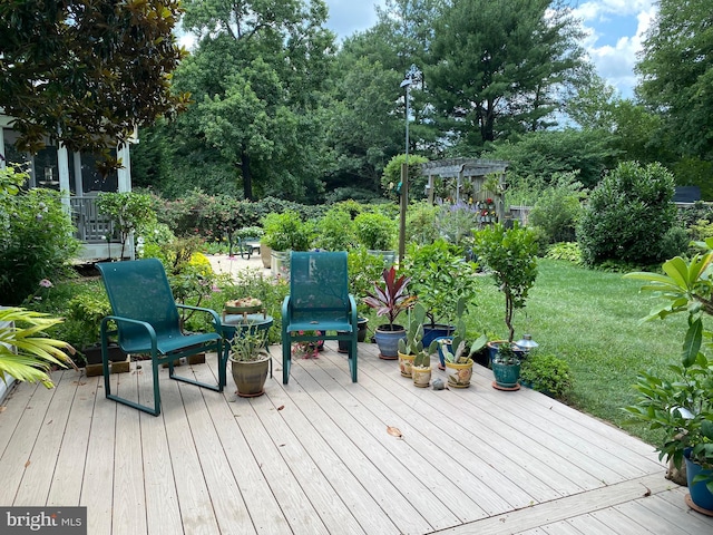 deck featuring a pergola and a yard