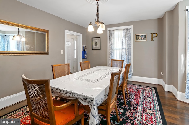 dining area with dark hardwood / wood-style flooring and a chandelier