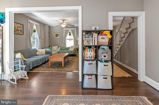 living room with ceiling fan and dark hardwood / wood-style flooring