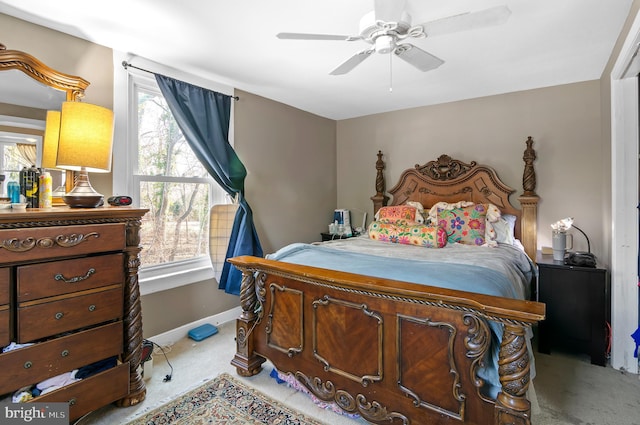 bedroom with light colored carpet, multiple windows, and ceiling fan