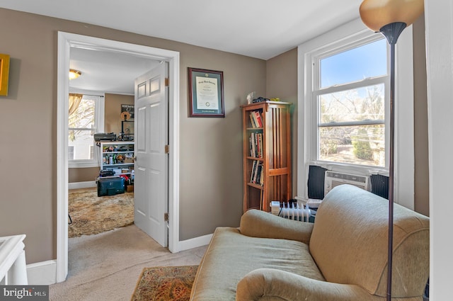 living area with plenty of natural light, cooling unit, light colored carpet, and radiator heating unit