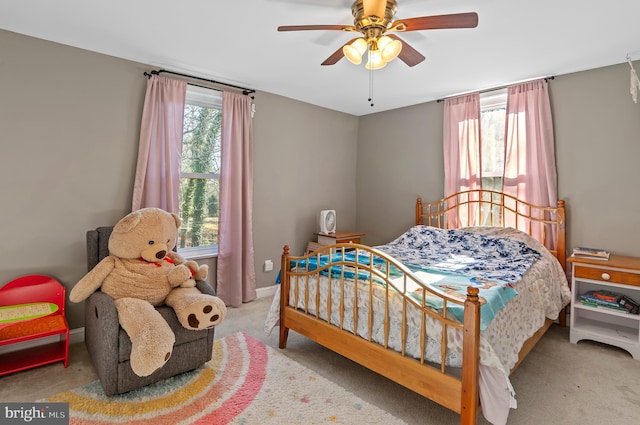 bedroom with ceiling fan, light carpet, and multiple windows