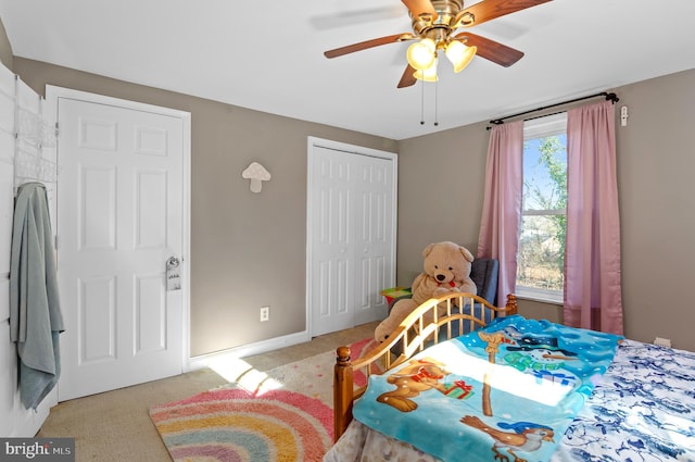 bedroom with a closet, ceiling fan, and light colored carpet