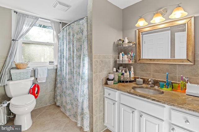 bathroom featuring curtained shower, tile patterned floors, toilet, vanity, and tile walls