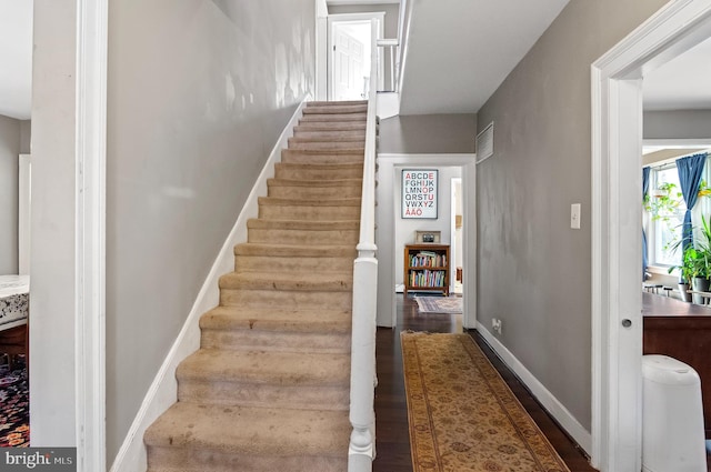 stairs featuring hardwood / wood-style floors