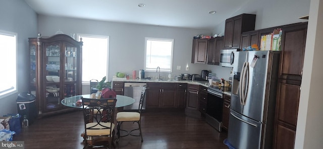 kitchen featuring sink, dark hardwood / wood-style floors, light stone countertops, dark brown cabinetry, and stainless steel appliances