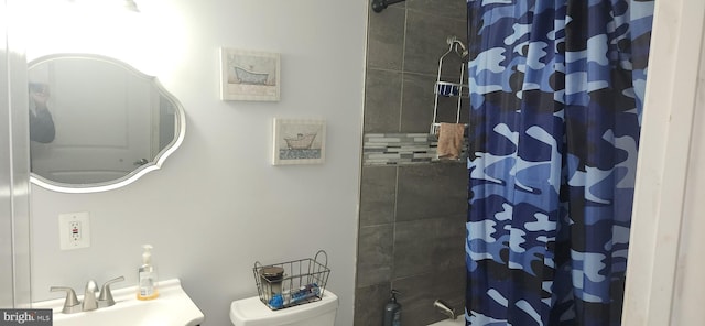 bathroom featuring a shower with shower curtain, toilet, and sink