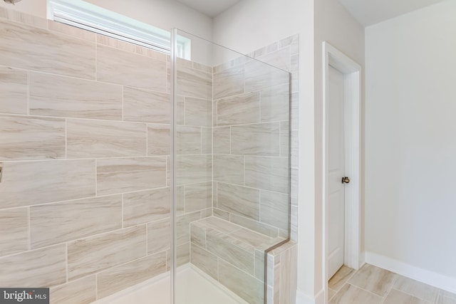 bathroom with tiled shower and tile patterned floors