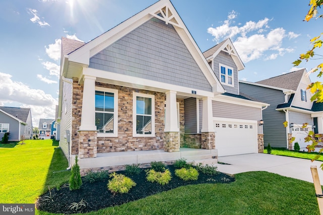 craftsman-style house featuring a garage, covered porch, and a front yard