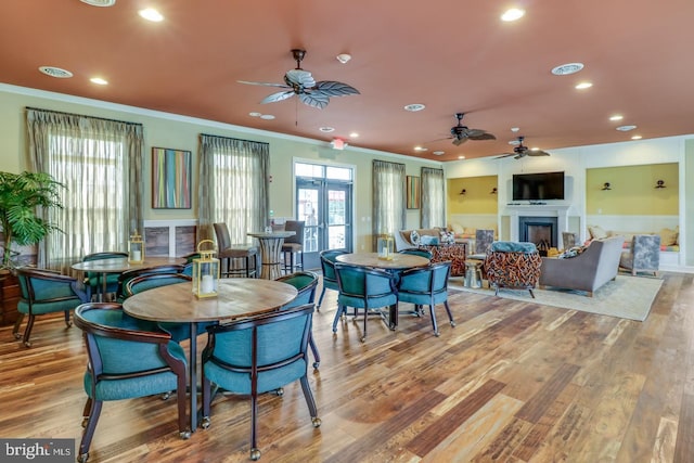 dining room with french doors, ornamental molding, and light wood-type flooring