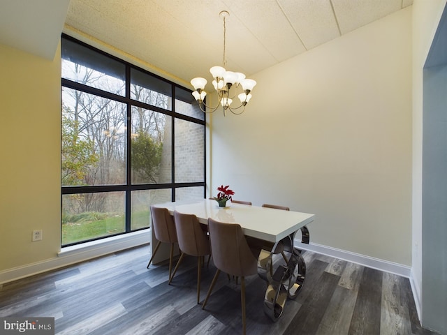 dining space with dark hardwood / wood-style flooring, a wall of windows, and a chandelier