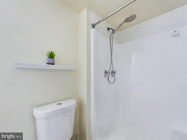 bathroom featuring a shower and toilet