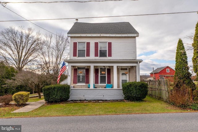 view of front of house with covered porch and a front yard