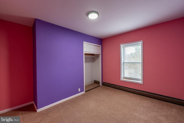 unfurnished bedroom featuring light carpet, a baseboard radiator, and a closet