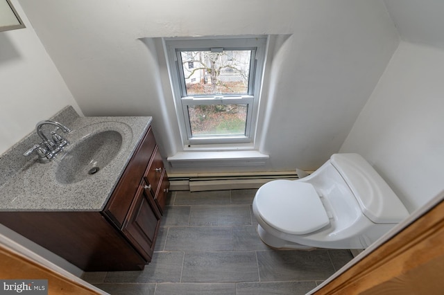 bathroom featuring vanity, toilet, and baseboard heating