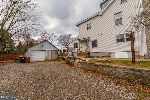 back of house featuring an outdoor structure and a garage